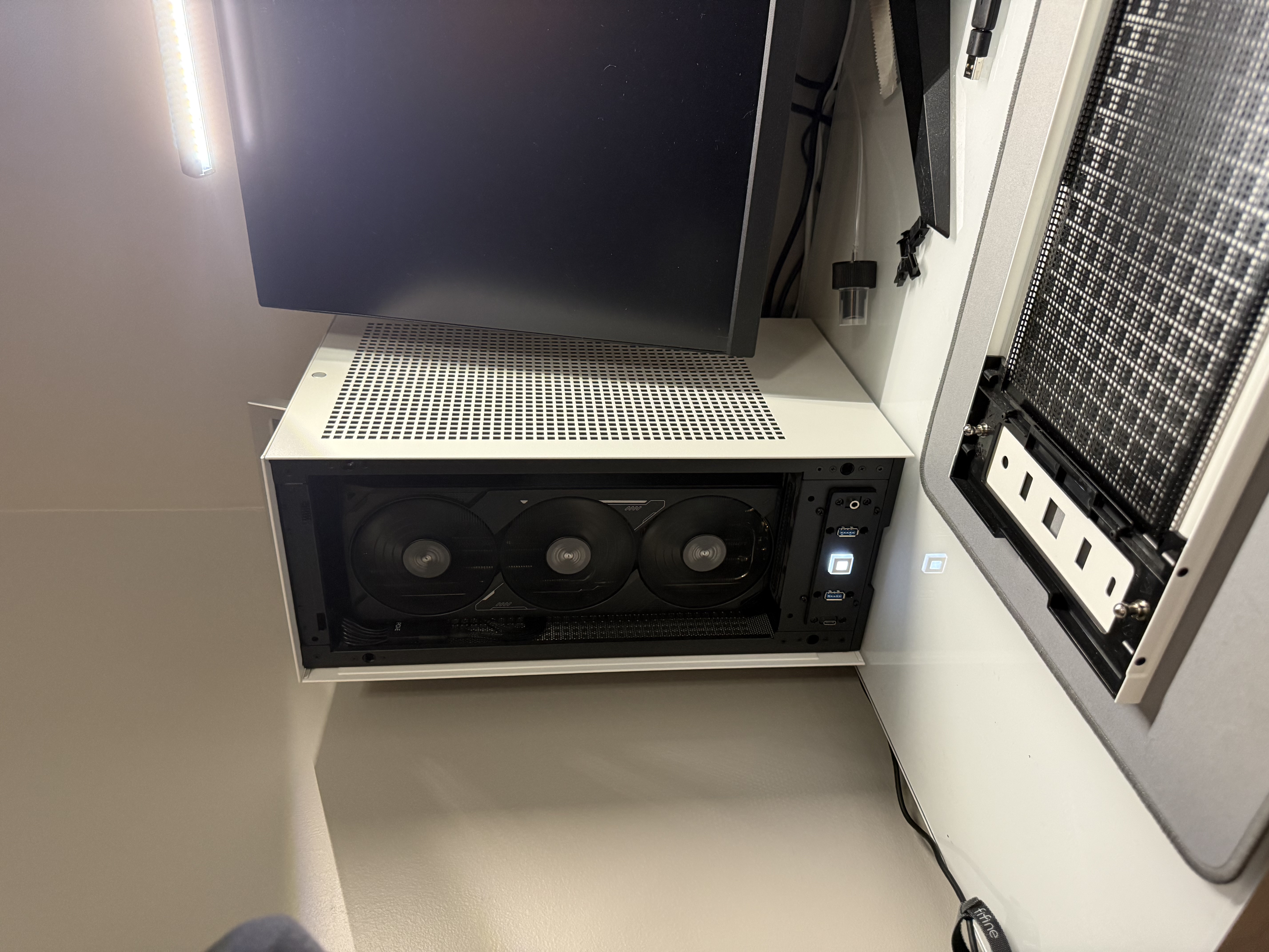 A picture of a small form factor computer next to a monitor.